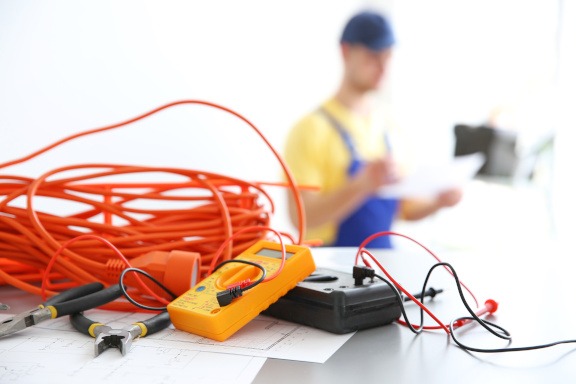 Electric equipment and blurred electrician on background Im Vordergrund elektrische Ausrüstung und im Hintergrund ein Elektriker bei Elektroinstallation in Bonn